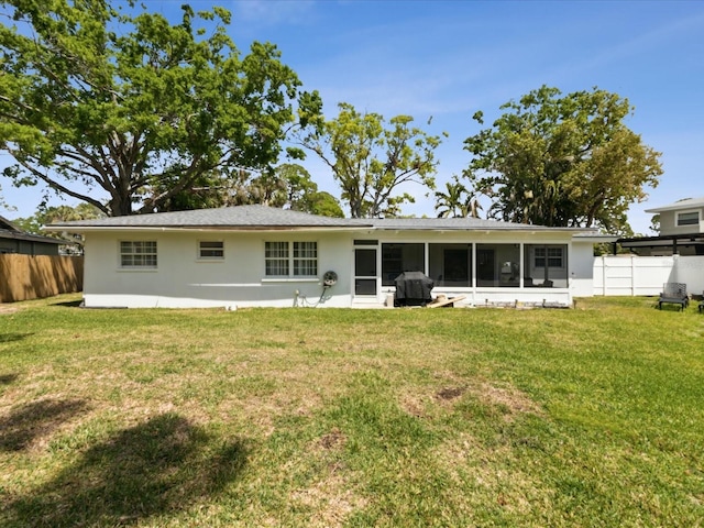 1666 N Dakota Ave NE, Saint Petersburg, FL 33703 - rear view of property featuring stucco siding, a sunroom, fence, and a yard