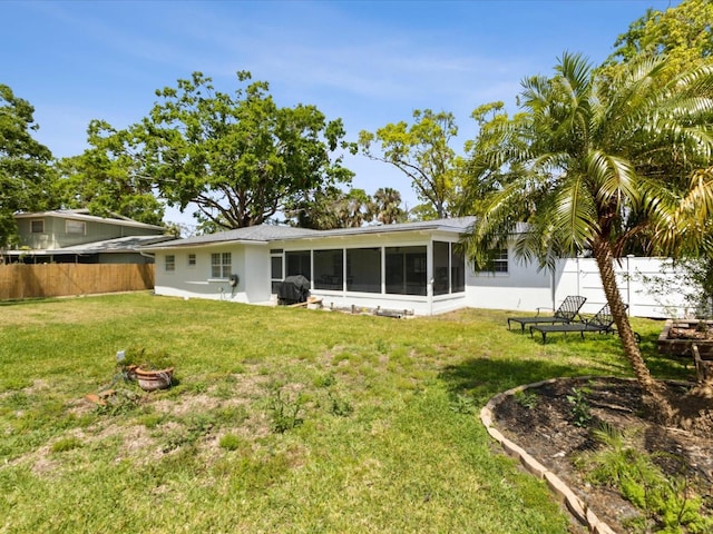 1666 N Dakota Ave NE, Saint Petersburg, FL 33703 - back of property with stucco siding, a sunroom, fence, and a yard