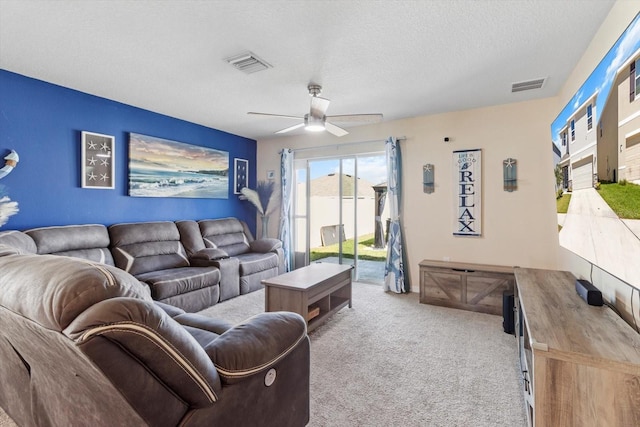 carpeted living room with a ceiling fan, a textured ceiling, and visible vents