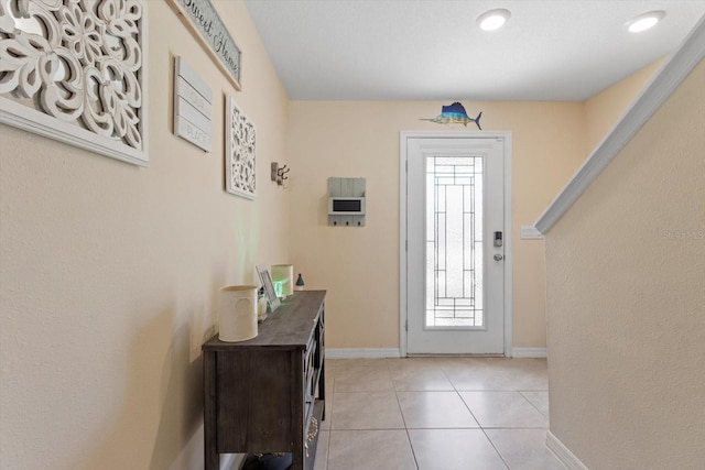 entrance foyer featuring light tile patterned floors and baseboards