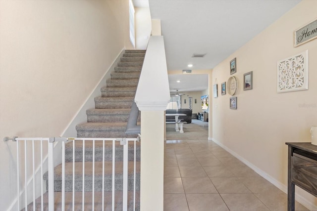 stairway with tile patterned floors and baseboards
