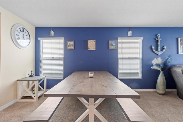 dining area featuring carpet flooring and baseboards