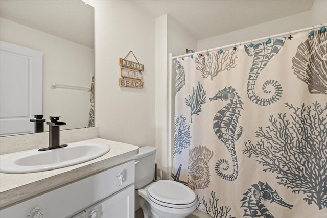 bathroom with curtained shower, toilet, and vanity