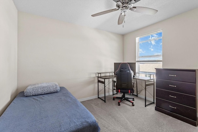 carpeted bedroom with a textured ceiling, baseboards, and ceiling fan