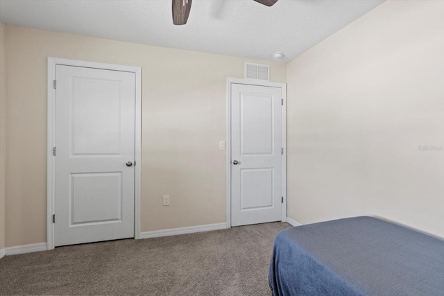 bedroom with baseboards, a ceiling fan, visible vents, and carpet