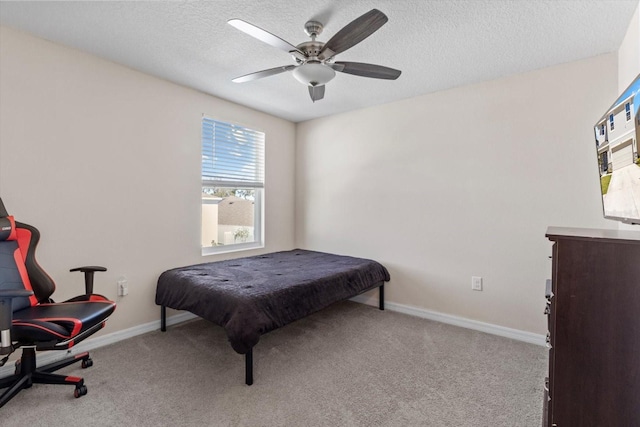 carpeted bedroom featuring baseboards, a ceiling fan, and a textured ceiling