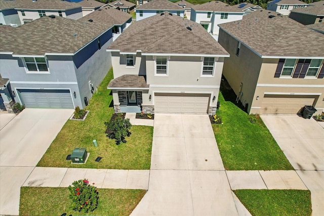 view of front facade featuring stucco siding, an attached garage, a front lawn, and driveway