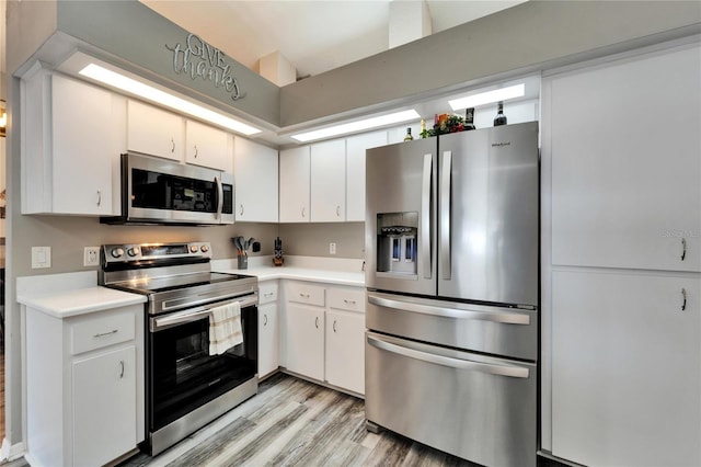 kitchen featuring stainless steel appliances, light wood-type flooring, light countertops, and white cabinetry
