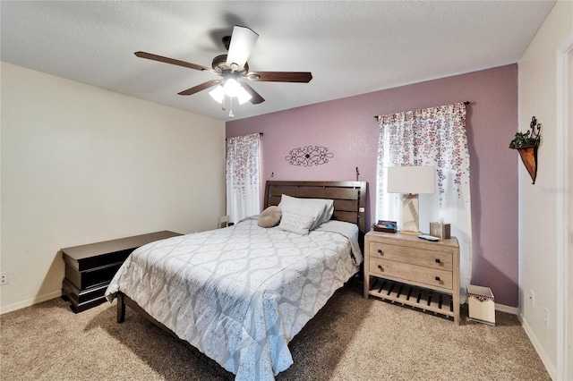 carpeted bedroom with baseboards, a ceiling fan, and a textured ceiling