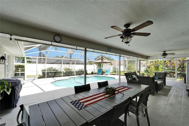exterior space with a fenced in pool, a ceiling fan, a patio area, glass enclosure, and fence