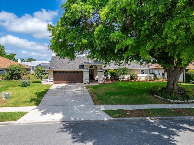 ranch-style home with a front lawn, a shingled roof, a garage, and concrete driveway
