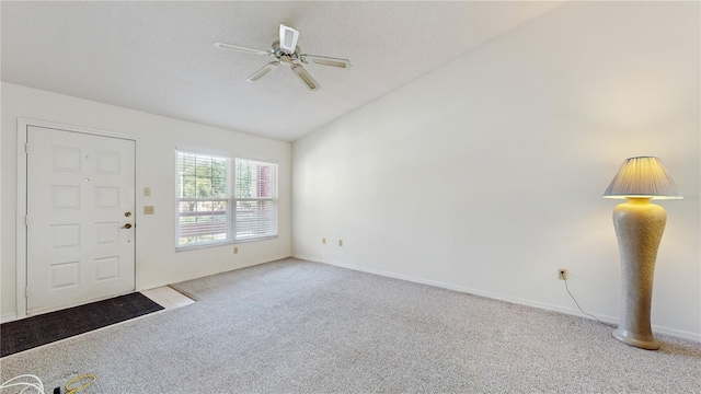 entryway with vaulted ceiling, carpet floors, ceiling fan, and baseboards
