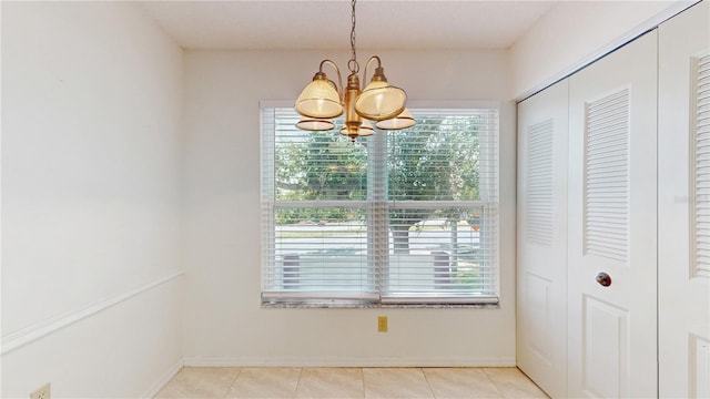 unfurnished dining area with a chandelier and baseboards