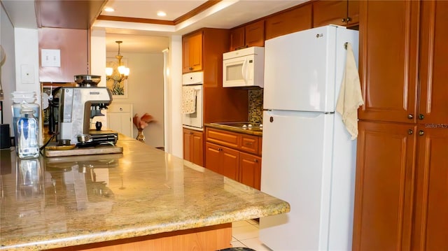 kitchen featuring decorative light fixtures, recessed lighting, white appliances, backsplash, and a notable chandelier