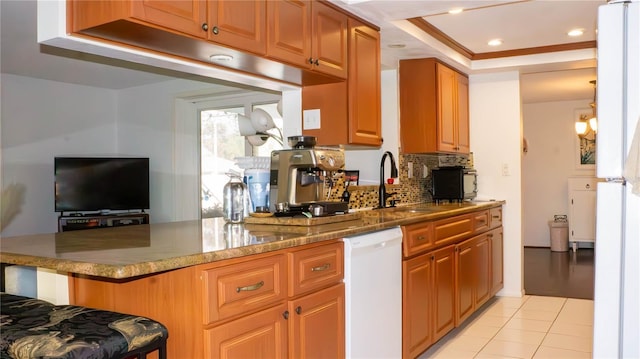 kitchen with decorative backsplash, light tile patterned flooring, a peninsula, a breakfast bar, and white dishwasher