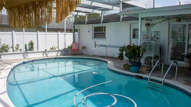 view of swimming pool with a fenced in pool, glass enclosure, fence, and a patio area