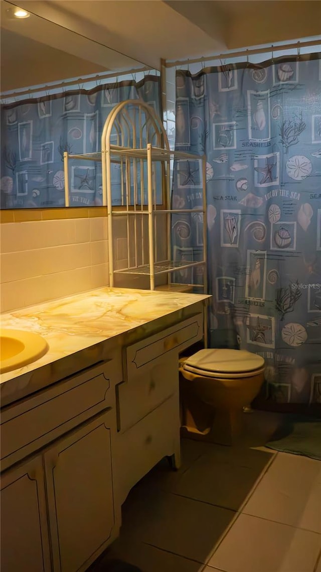 bathroom featuring tile patterned flooring, a shower with shower curtain, toilet, vanity, and backsplash