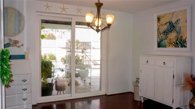 interior space with dark wood finished floors and a chandelier