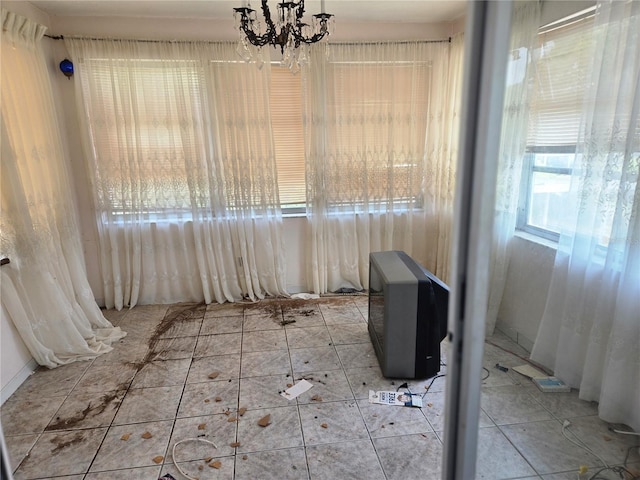 unfurnished dining area featuring tile patterned floors and a notable chandelier