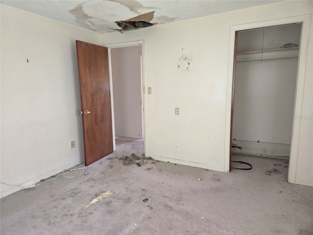 unfurnished bedroom with concrete floors and a closet