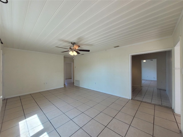 empty room featuring ornamental molding, light tile patterned floors, ceiling fan, and baseboards