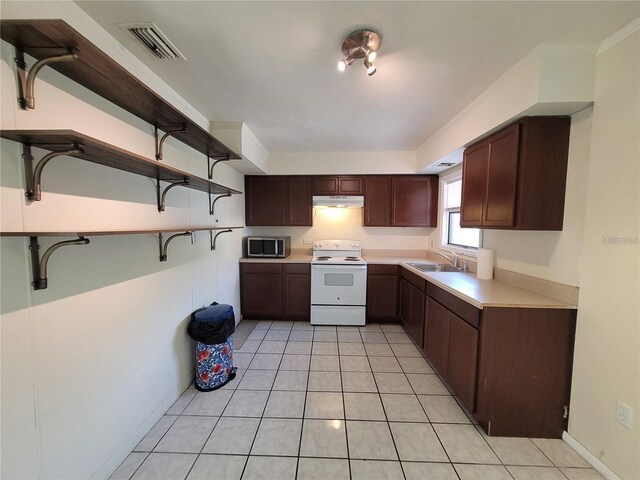 kitchen featuring stainless steel microwave, light countertops, open shelves, visible vents, and white range with electric cooktop