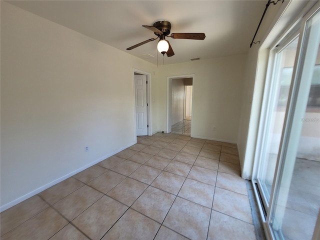 empty room featuring visible vents, baseboards, a ceiling fan, and light tile patterned floors