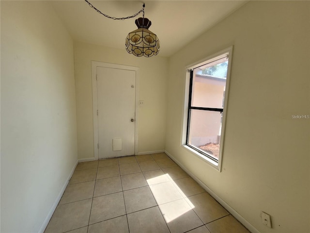 interior space with light tile patterned floors and baseboards