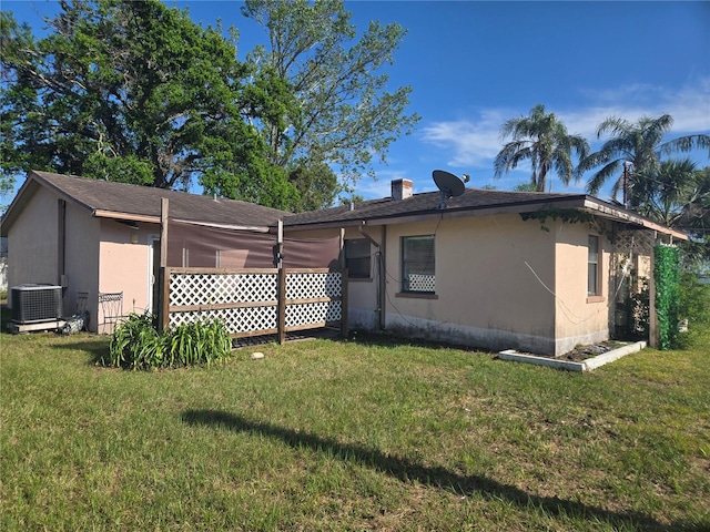 view of property exterior featuring central air condition unit, roof with shingles, stucco siding, and a lawn