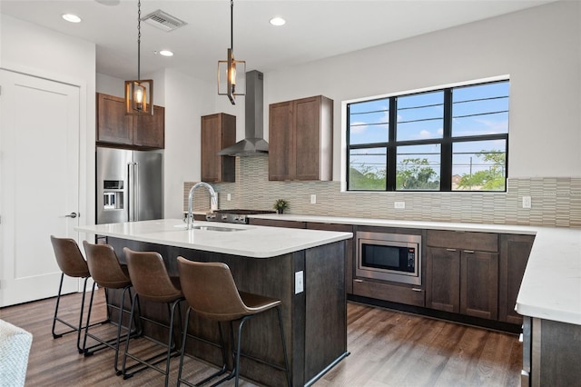907 Arlington Ave N, Saint Petersburg, FL 33705 - kitchen with visible vents, wall chimney range hood, dark wood finished floors, and appliances with stainless steel finishes