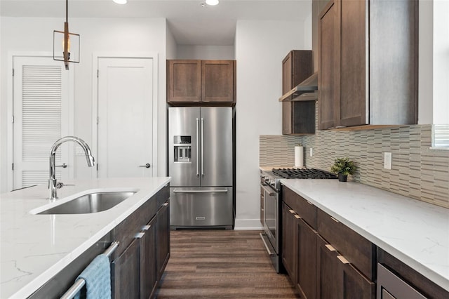 907 Arlington Ave N, Saint Petersburg, FL 33705 - kitchen featuring dark wood-style flooring, stainless steel appliances, exhaust hood, backsplash, and a sink