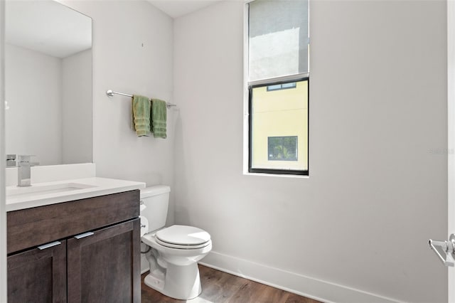 907 Arlington Ave N, Saint Petersburg, FL 33705 - bathroom with baseboards, wood finished floors, toilet, and vanity