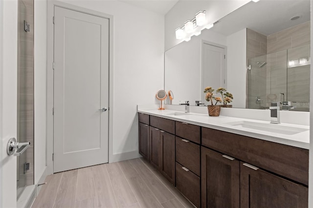907 Arlington Ave N, Saint Petersburg, FL 33705 - full bathroom featuring a shower stall, double vanity, wood finished floors, and a sink