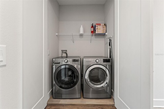 907 Arlington Ave N, Saint Petersburg, FL 33705 - clothes washing area featuring independent washer and dryer, wood finished floors, and laundry area