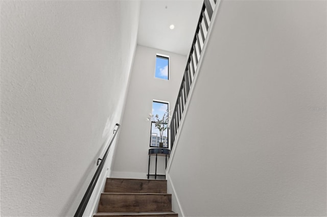 907 Arlington Ave N, Saint Petersburg, FL 33705 - stairs with baseboards, wood finished floors, and a towering ceiling