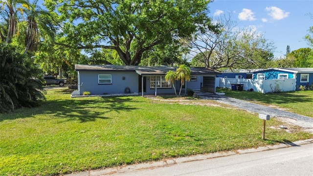 1411 Barry St, Clearwater, FL 33756 - ranch-style home featuring driveway, an attached carport, stucco siding, fence, and a front lawn