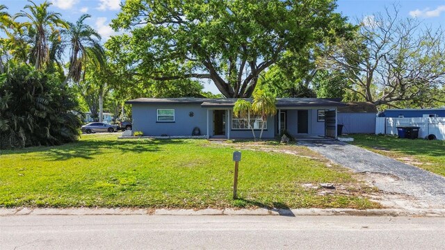 1411 Barry St, Clearwater, FL 33756 - ranch-style house featuring stucco siding, aphalt driveway, a front yard, and a carport