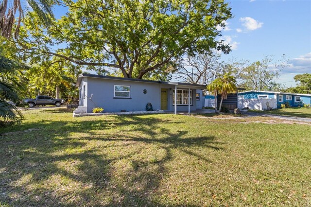 1411 Barry St, Clearwater, FL 33756 - view of front facade featuring stucco siding and a front lawn
