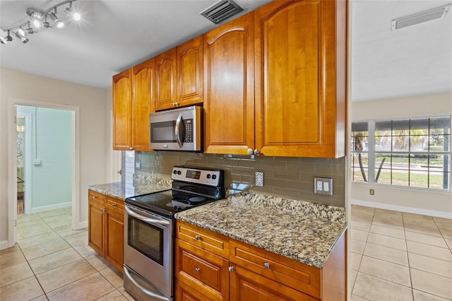1411 Barry St, Clearwater, FL 33756 - kitchen featuring light tile patterned floors, appliances with stainless steel finishes, light stone counters, and visible vents