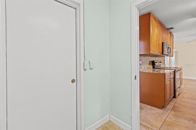 1411 Barry St, Clearwater, FL 33756 - kitchen featuring tasteful backsplash, stainless steel appliances, light stone counters, visible vents, and brown cabinets