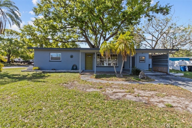 1411 Barry St, Clearwater, FL 33756 - single story home featuring an attached carport, a front yard, stucco siding, and aphalt driveway
