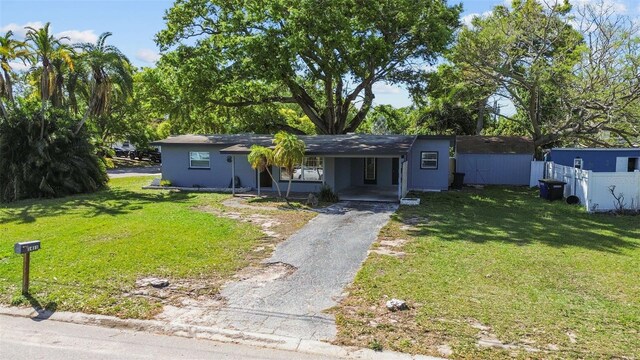 1411 Barry St, Clearwater, FL 33756 - view of front of home featuring driveway, fence, a front yard, and a carport