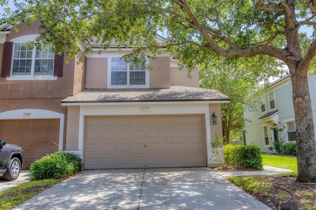 view of property featuring an attached garage, stucco siding, and concrete driveway