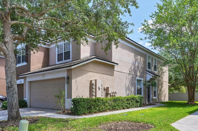 view of side of home with stucco siding, a garage, concrete driveway, and a lawn