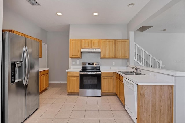 kitchen with appliances with stainless steel finishes, under cabinet range hood, a sink, light tile patterned floors, and light countertops
