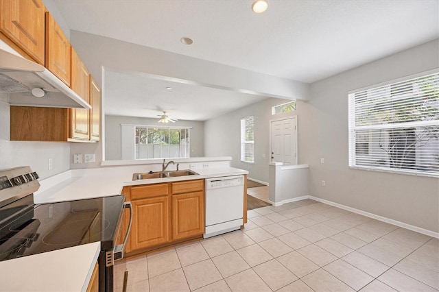 kitchen featuring white dishwasher, stainless steel range with electric cooktop, a sink, a peninsula, and light countertops