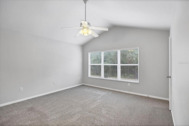 carpeted empty room featuring ceiling fan, lofted ceiling, baseboards, and a textured ceiling