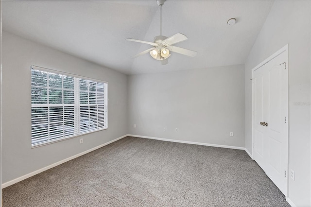unfurnished bedroom featuring carpet floors, baseboards, ceiling fan, and lofted ceiling