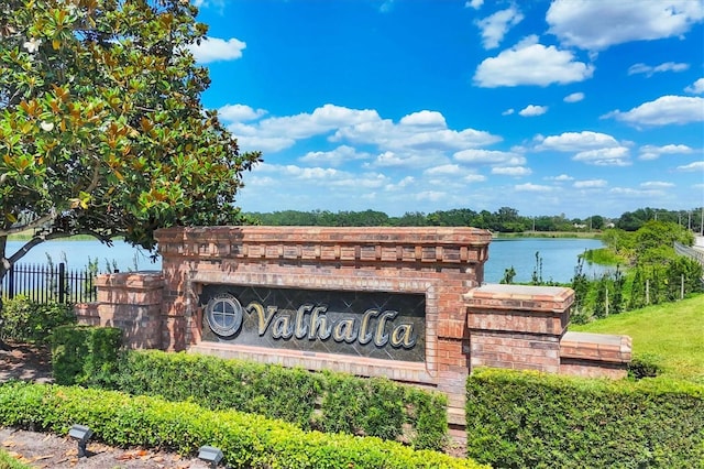 community sign with fence and a water view