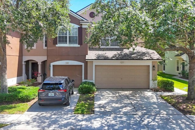 townhome / multi-family property featuring stucco siding, a garage, and concrete driveway